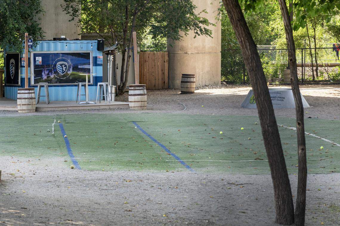Tennis balls sit scattered across the dog park at Bar K on Tuesday, July 30, 2025, in Kansas City, Missouri. The dog bar and park permanently closed this week, citing riverfront construction and financial pressures.