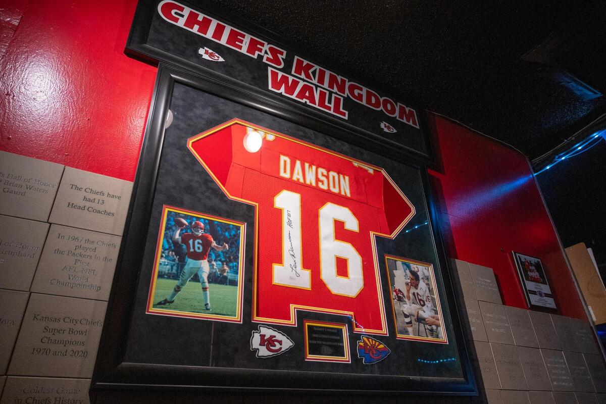 A framed signed jersey of former Kansas City Chiefs quarterback Len Dawson is displayed on a wall among decorative tiles bearing significant symbols related to the team at Pub Rock on Thursday, Feb. 8, 2024, in Scottsdale, Ariz.