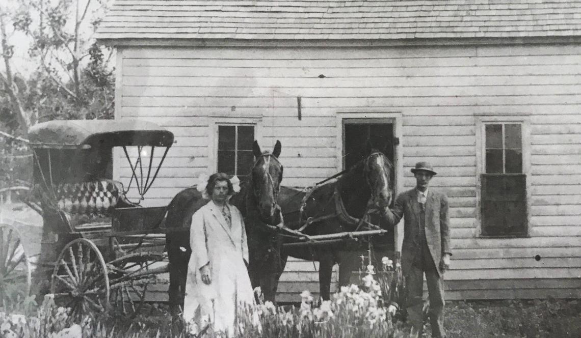 Cecil Van Tuyl’s parents stand outside his boyhood home in La Cygne, Kansas. Van Tuyl in the 1950s went from fixing cars to selling them, growing wealthy as a result.