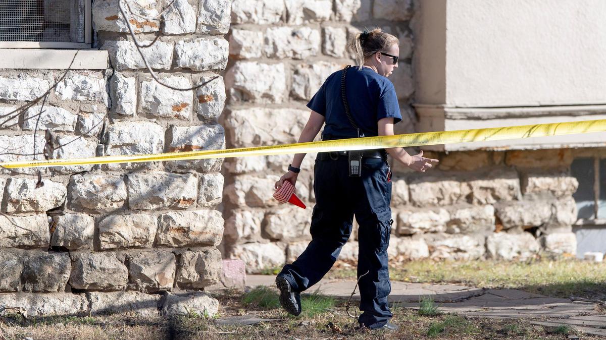 A crime scene investigator walks near the scene of a double homicide Tuesday at the intersection of East 28th Street and Prospect Avenue in Kansas City.