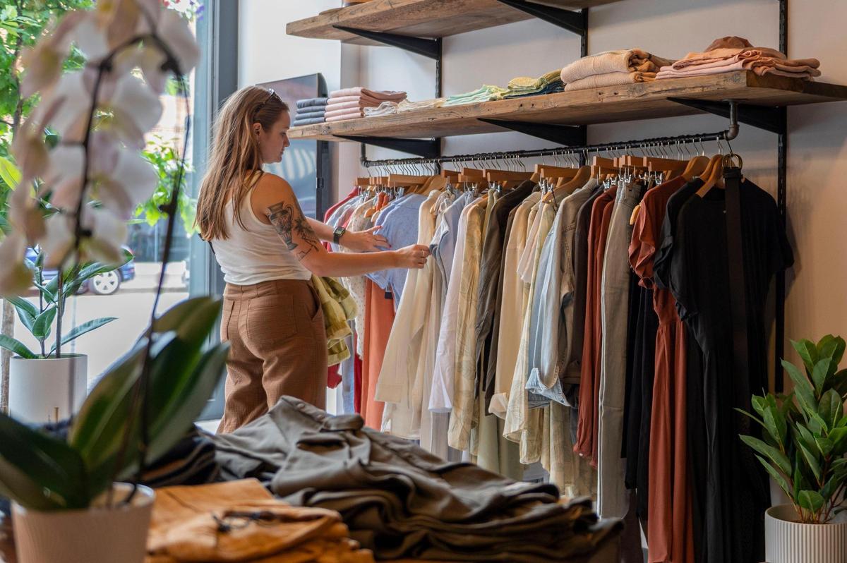 A customer looks through a rack of clothing at The Normal Brand, a men’s and women’s apparel store based in St. Louis.