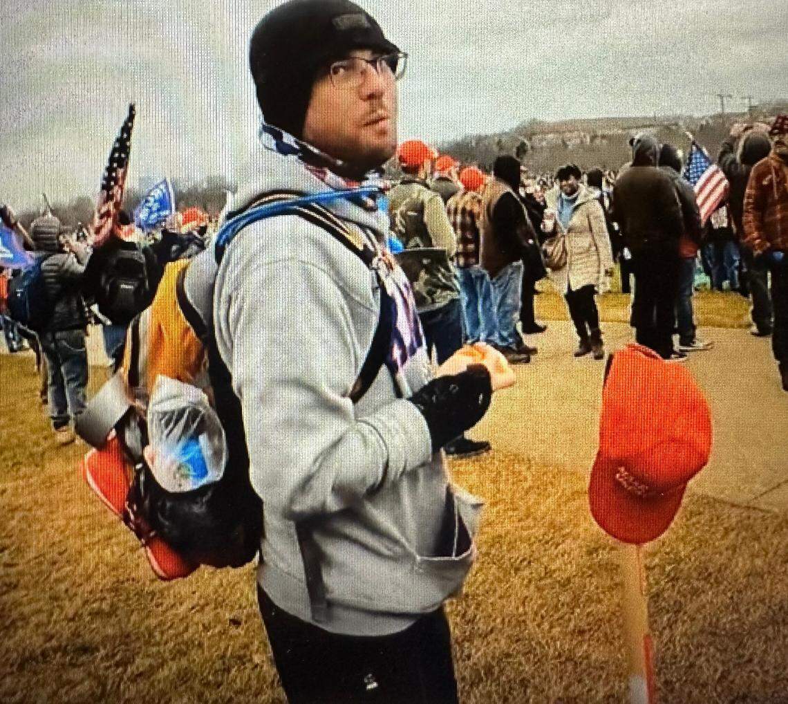 Christopher Roe at the pro-Trump “Stop the Steal” rally on Jan. 6, 2021. In front of Roe is a pitchfork stuck in the ground, topped with a red baseball cap.