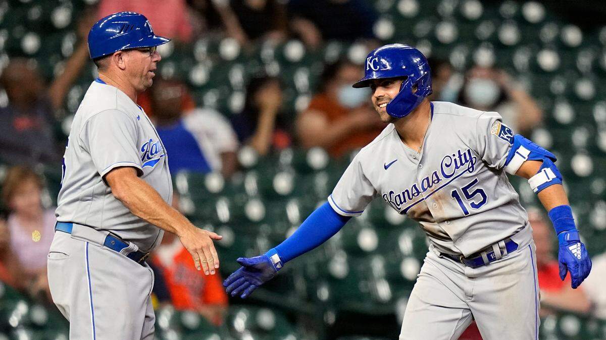 Kansas City Royals’ Whit Merrifield (15) celebrates with third base coach Vance Wilson after hitting a two-run triple against the Houston Astros during the eighth inning of a baseball game Monday, Aug. 23, 2021, in Houston. (AP Photo/David J. Phillip)