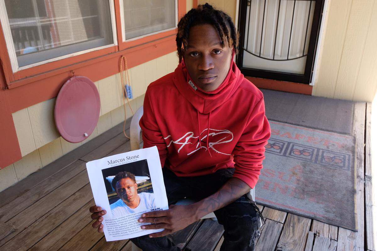 Ke’Shawn Stone, 21, holds a photo of his brother Marcus, who was shot and killed this year at 18th and Vine in Kansas City. It’s one of many unsolved homicides in the city.