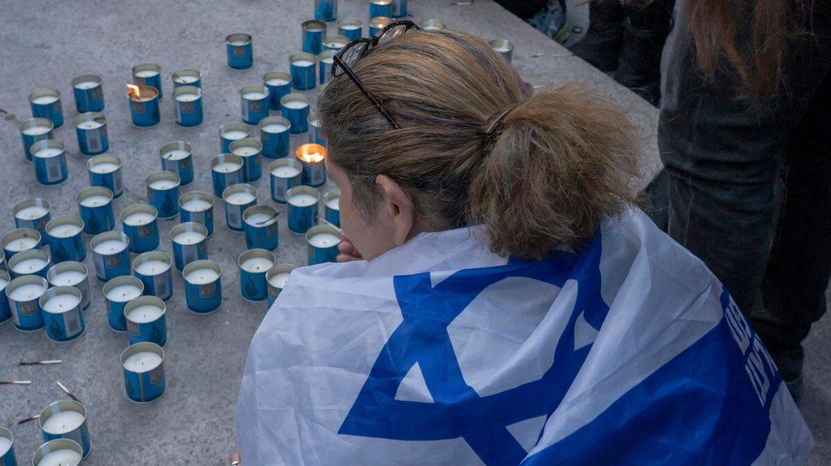 A woman draped with an Israeli flag sits at a candlelight vigil for the 1400 victims of the October 7 Hamas terrorist attacks in Israel at Central Park in New York City. Thousands of civilians, both Palestinians and Israelis, have died since October 7, 2023, after Palestinian Hamas terrorist based in the Gaza Strip entered southern Israel in an unprecedented attack triggering a war declared by Israel on Hamas. (Photo by Ron Adar / SOPA Images/Sipa USA)