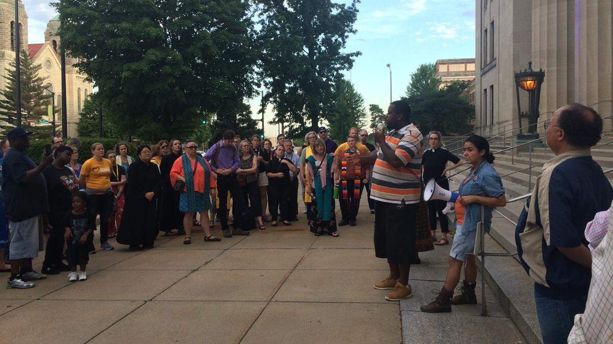 LJ Brackson (speaking) and some 100 others gathered Tuesday evening outside the Wyandotte County Courthouse to celebrate Juneteenth.
