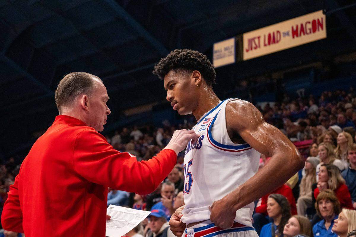 Kansas Jayhawks forward Bryson Tiller (15) talks to assistant coach Joe Dooley in the second half of the game vs. the Towson Tigers on Tuesday, December 16, 2025, at Allen Fieldhouse.