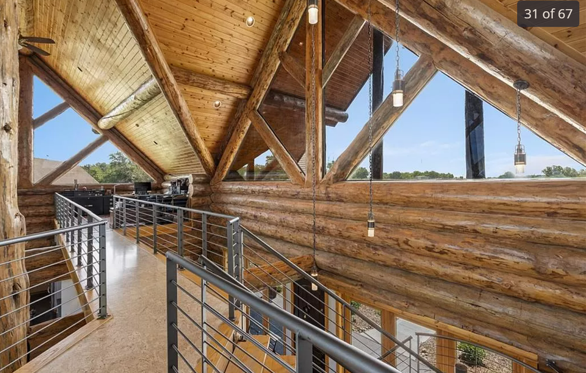 An elevated catwalk leads to the loft office in the log cabin-style home at 13708 South Missouri 7 Highway.