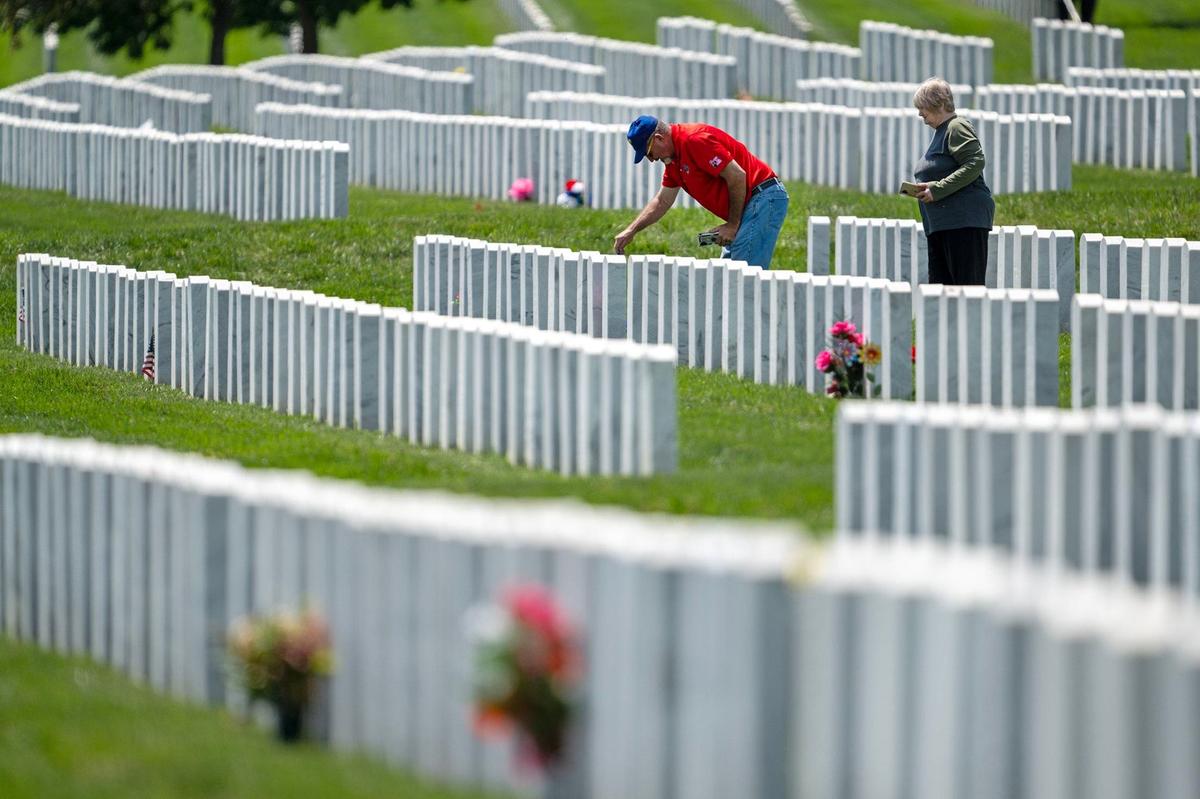 Mike and Brenda DeGraw of Lebanon, Missouri, pay tribute to Mike’s father, John Francis DeGraw, a veteran of the U.S. Coast Guard and of the Army Reserve, during a visit to Leavenworth National Cemetery on Thursday, May 23, 2024, ahead of the Memorial Day holiday.
