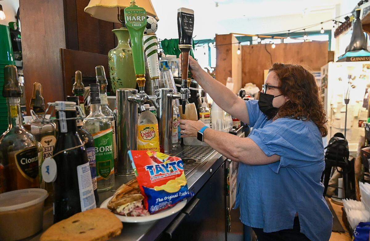 Kerry Browne pours a Guinness into a glass at Browne’s Irish Marketplace, which, she says, has one of the oldest liquor licenses in Kansas City.
