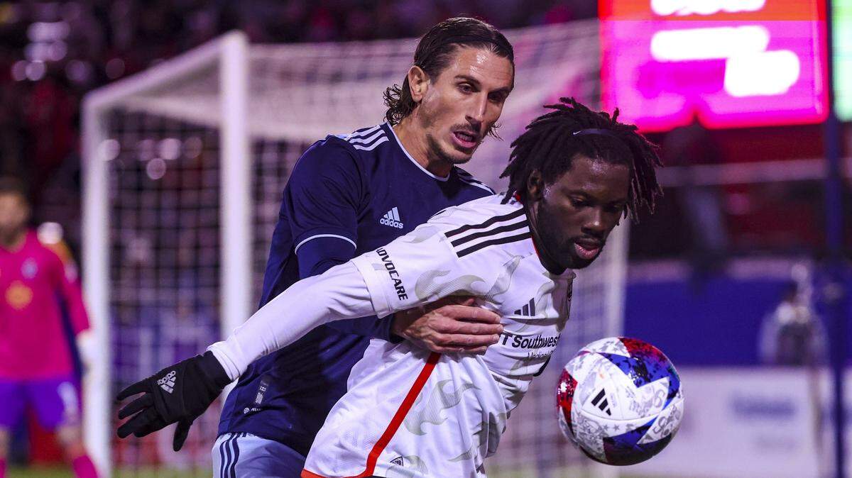 Sporting Kansas City defender Ben Sweat, at rear, battles FC Dallas midfielder Ema Twumasi for the ball Saturday night in Texas.