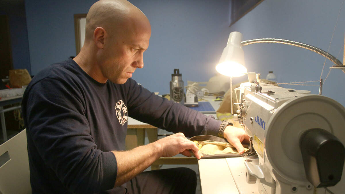 Capt. Andy Fenstermann of the John B. Glaser Fire Station in Shawnee works on a patch for another firefighter’s pants. Repairing their gear in-house saves the department a significant amount of waiting time and money.