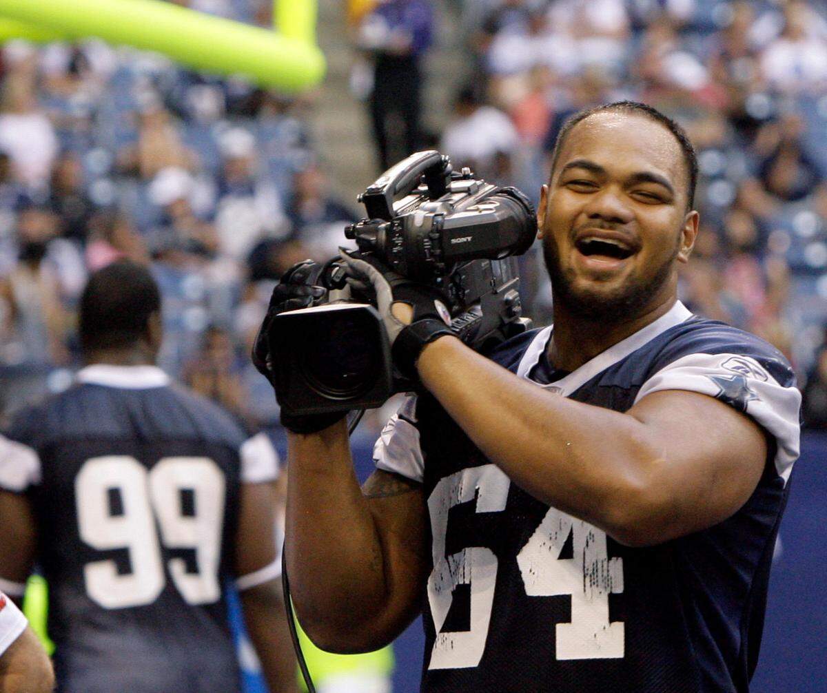 Junior Siavii grabs a TV camera at Dallas Cowboys training camp during the filming of HBO’s 2008 season of “Hard Knocks.” He played for the Cowboys in 2009, and then was cut by the team.