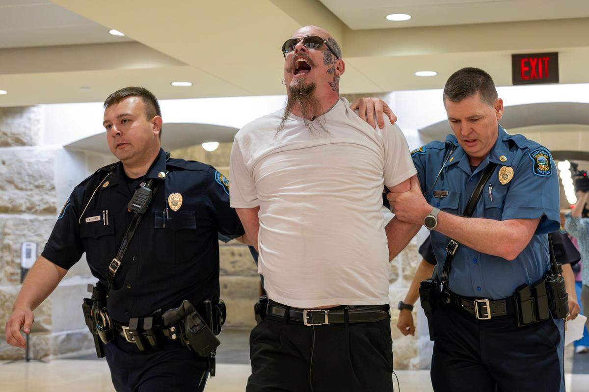 Satanic Grotto leader Michael Stewart is led away by Capitol police officers after being arrested when he got into an altercation while he attempted to perform the Black Mass ritual inside the Kansas State Capitol on Friday, March 28, 2025, Topeka.
