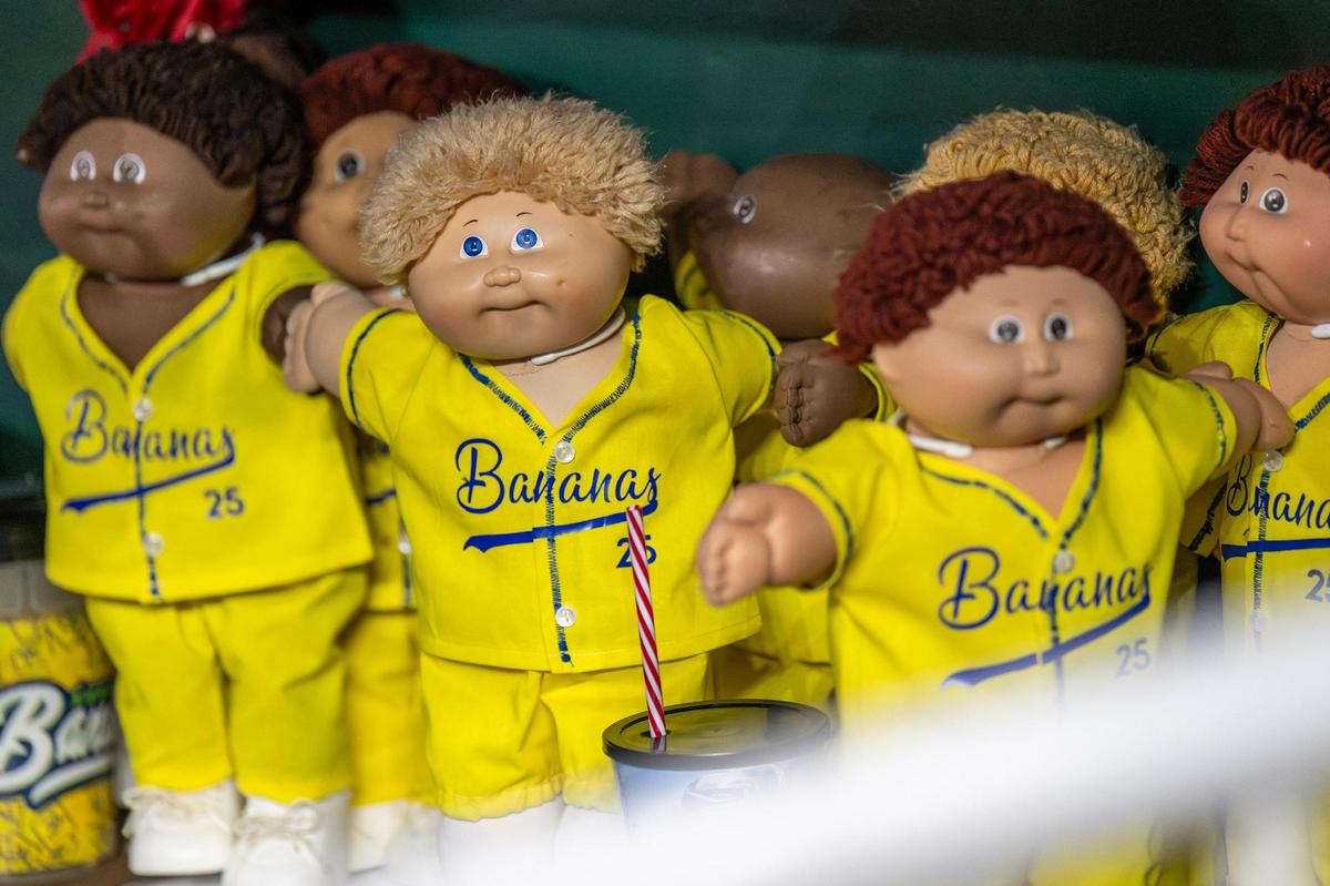 A batch of Cabbage Patch Kids dolls dressed in Savannah Bananas attire resembling players on the team are seen in the dugout during a Banana Ball game against the Firefighters at Kauffman Stadium on Friday, May 23, 2025, in Kansas City.