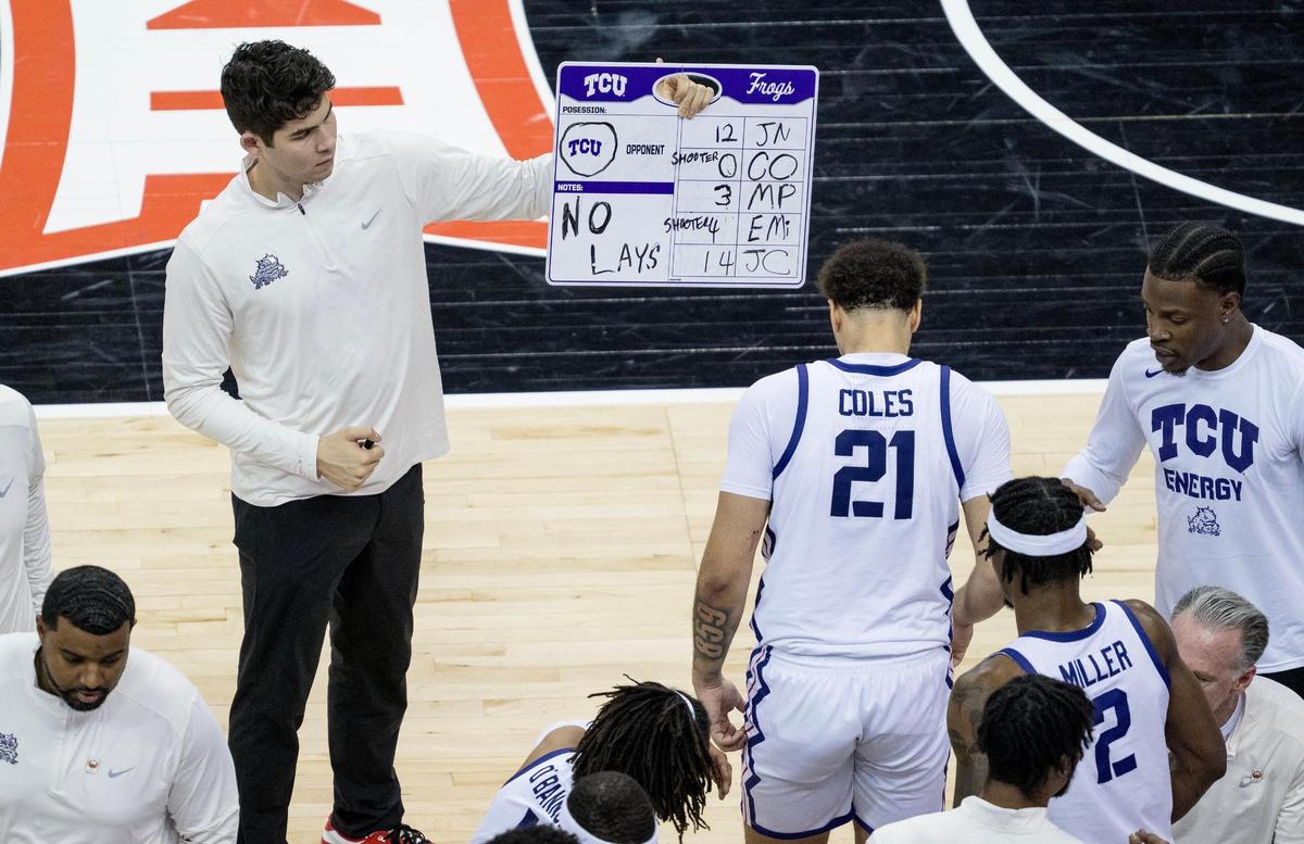 Even the coaches need some support during the game. Luke Webb, a graduate assistant for the TCU Horned Frogs, holds up notes for players during a break in the Frogs’ second round game with Oklahoma in the Big 12 men’s basketball tournament Wednesday at T-Mobile Center. .
