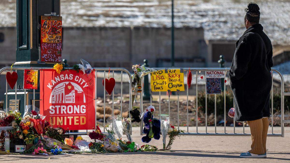 In this Feb. 18 photo a visitor takes a moment to look at a makeshift memorial at Union Station four days after a mass shooting left one person dead and more than 20 injured after the Kansas City Chiefs’ Super Bowl victory rally.