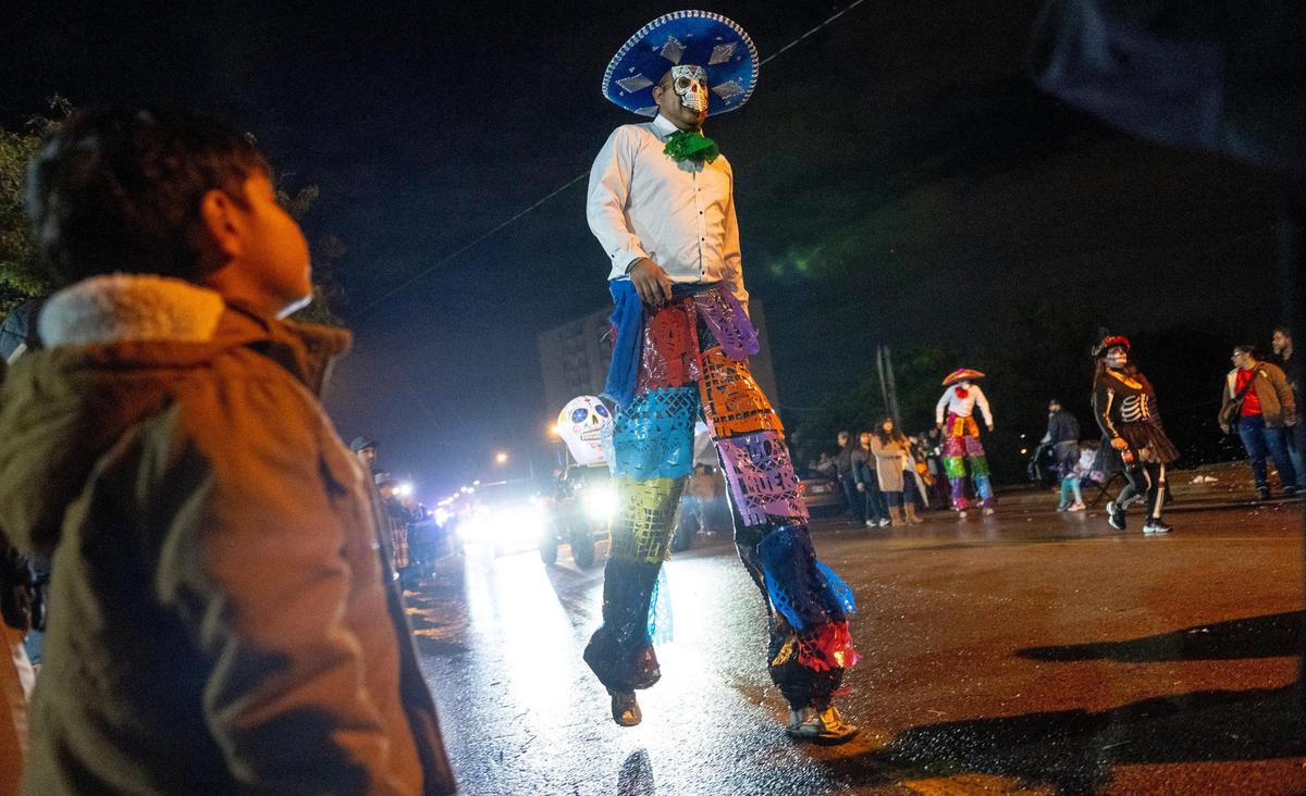 A man walks on stilts during the Dia de los Muertos parade hosted by the Central Avenue Betterment Association on Saturday in Kansas City, Kan.