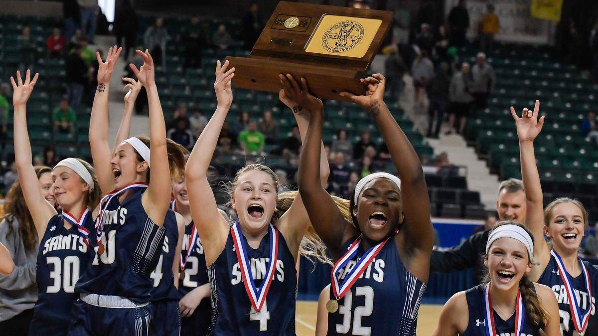 St. Thomas Aquinas players raised the state championship trophy after beating Bishop Carroll 54-40 on Saturday.