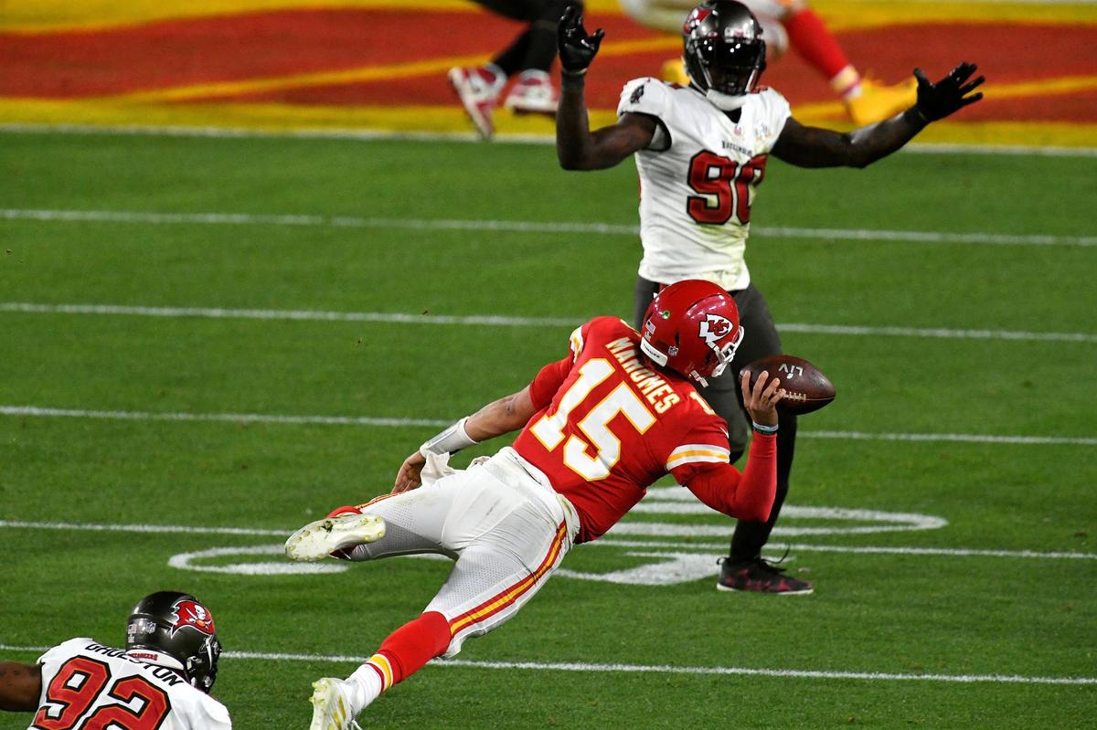 Kansas City Chiefs quarterback Patrick Mahomes is tripped up by Tampa Bay Buccaneers defensive end William Gholston and flies through the air as he gets off a pass to the end zone in the fourth quarter Sunday, February 7, 2021, at Super Bowl LV at Raymond James Stadium in Tampa, Florida. The pass was incomplete.