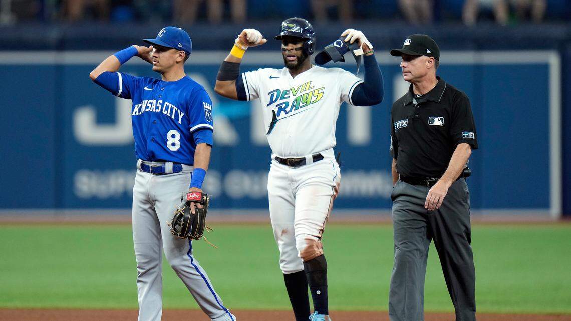Tampa Bay Rays’ Yandy Diaz, center, reacts to his RBI double off Kansas City Royals starting pitcher Kris Bubic during the fourth inning of a baseball game Saturday, Aug. 20, 2022, in St. Petersburg, Fla. Royals’ Nicky Lopez, left, and umpire Dan Iassogna, right, look on. (AP Photo/Chris O’Meara)