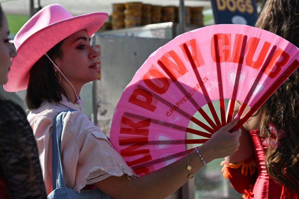 Tori Salano used her Pink Pony Club fan to cool off before the Chappell Roan Concert on Friday, Oct. 3, 2025, at the National WWI Museum and Memorial.