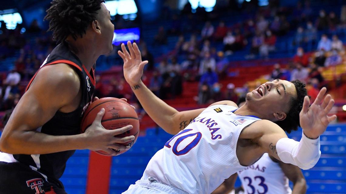 Texas Tech’s Terrence Shannon (left) charges into KU’s Jalen Wilson during the first half of Saturday’s Big 12 Conference game at Allen Fieldhouse.