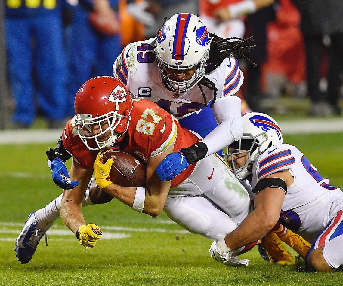 Kansas City Chiefs tight end Travis Kelce is taken down by a pair of Buffalo Bills defenders after making a pass reception in the first half Sunday, January 24, 2021, during the AFC Championship Game at Arrowhead Stadium in Kansas City, Missouri.