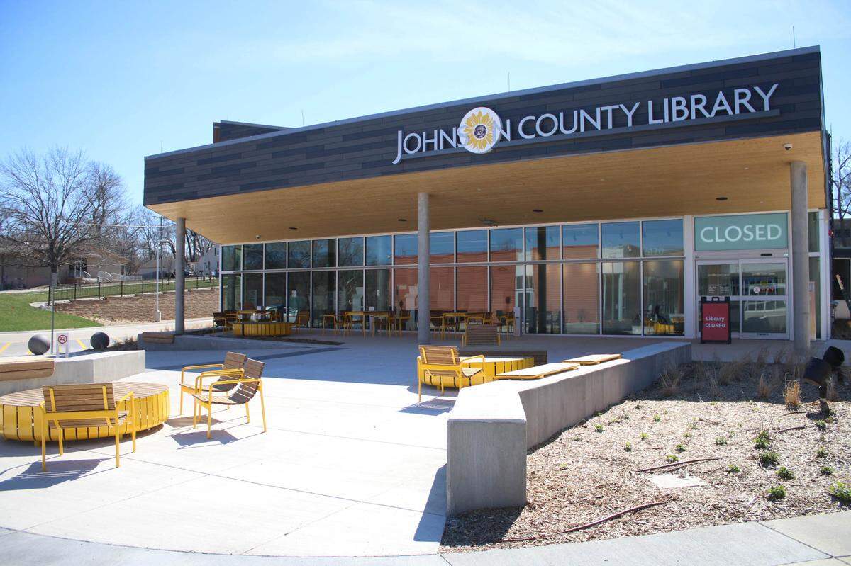 The front of Merriam Plaza Library shares a paved courtyard with the Merriam Community Center. The library also has covered seating directly in front of the building.