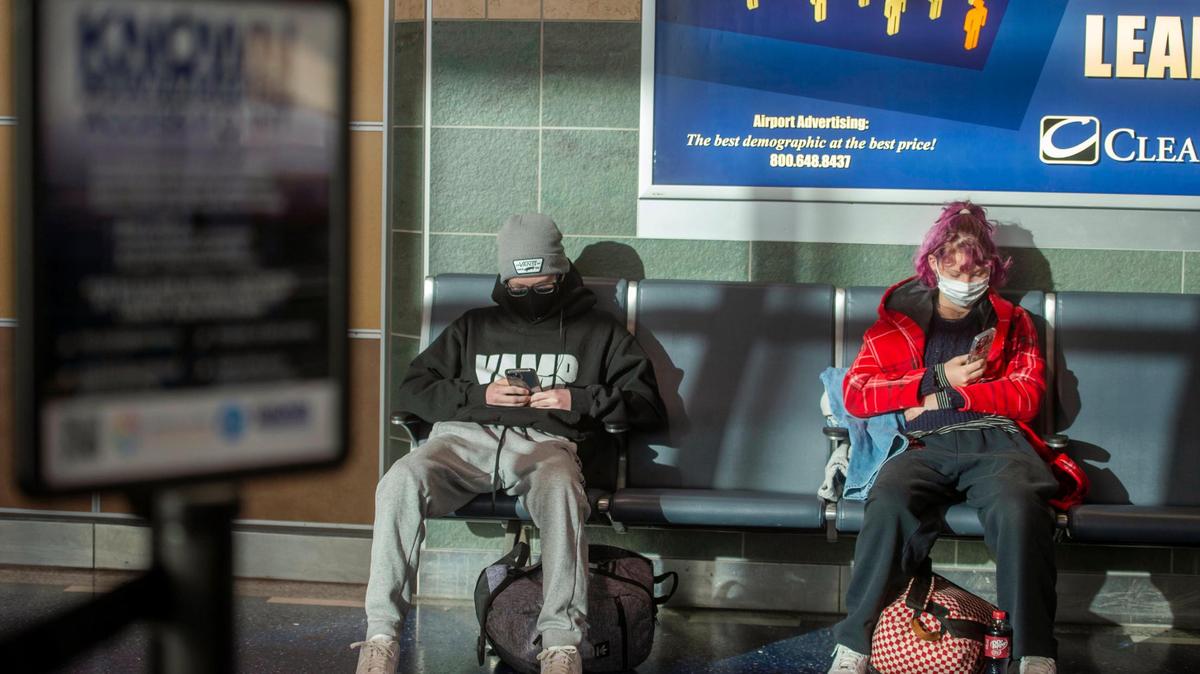Holiday travelers Griffin Darnold, left, and his sister Amilia Darnold wait for their plane to begin boarding on Wednesday at Kansas City International Airport.