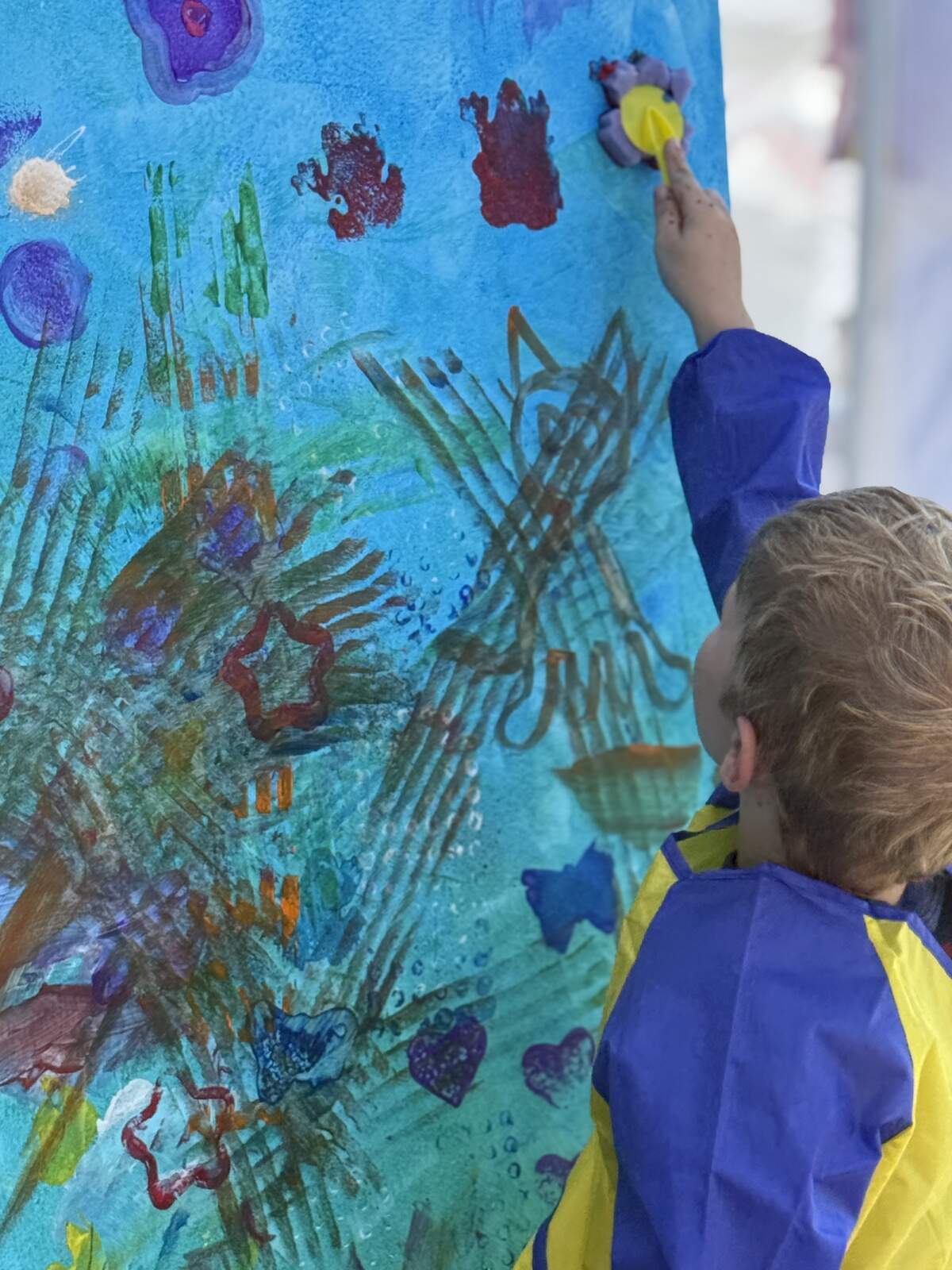 A child sponge-paints onto a blue banner at a previous Riverside ArtWalk event. This year, the July 3 celebration will have carnival games, a big bubble-maker, bounce houses, face paint, 24-person video game trailer and more. The kids zone will be open at the Morton Amphitheater-hosted event from 3:30 p.m. to 7:30 p.m.