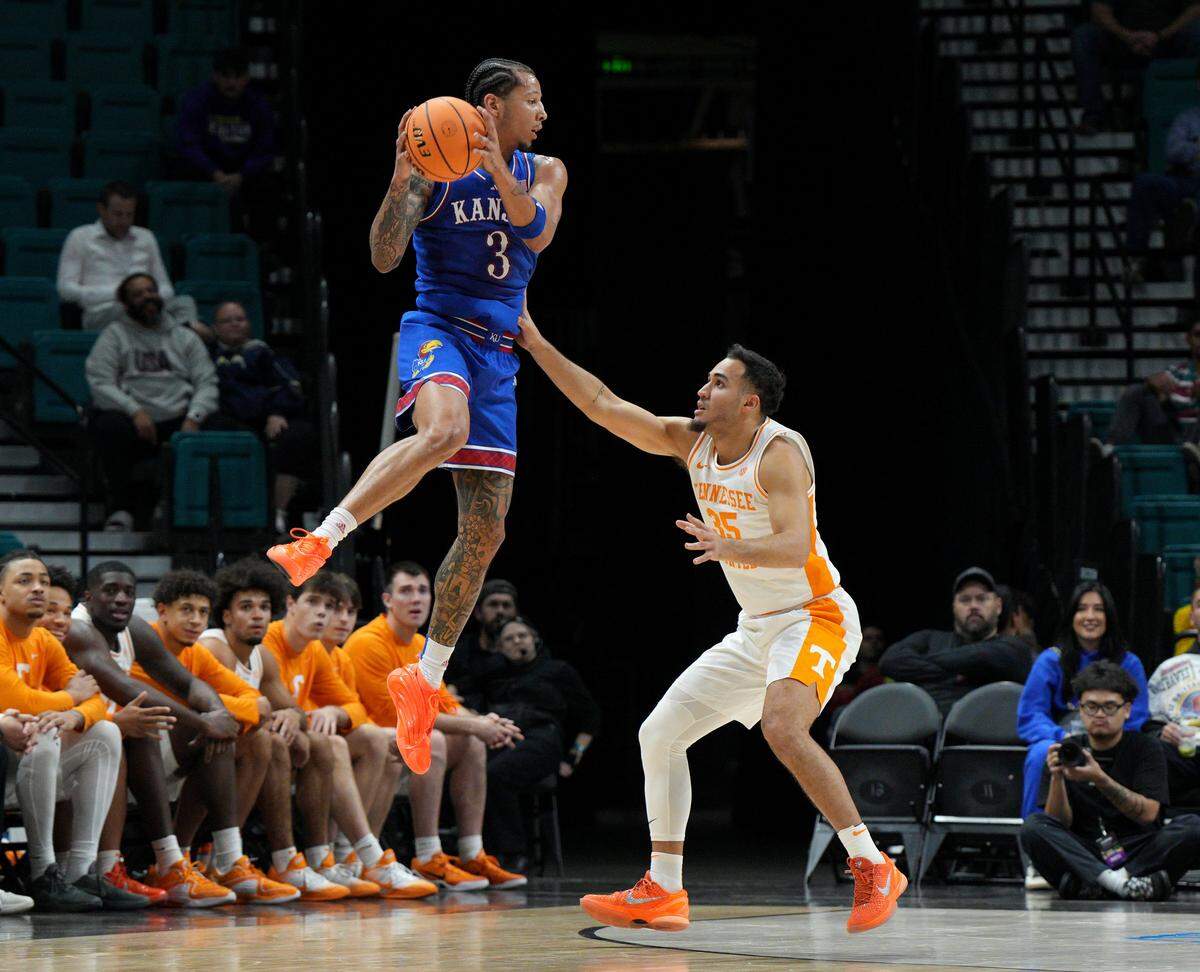 Kansas Jayhawks guard Tre White, left, goes airborne as Tennessee Volunteers guard Ethan Burg defends during a Players Era men’s basketball tournament game at the MGM Grand Garden Arena in Las Vegas on Wednesday, Nov. 26, 2025.