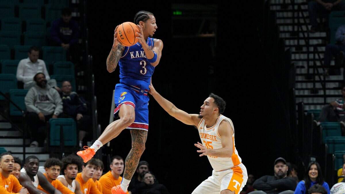 Kansas Jayhawks guard Tre White, left, goes airborne as Tennessee Volunteers guard Ethan Burg defends during the championship game of the Players Era men’s basketball tournament at the MGM Grand Garden Arena in Las Vegas on Wednesday, Nov. 26, 2025.