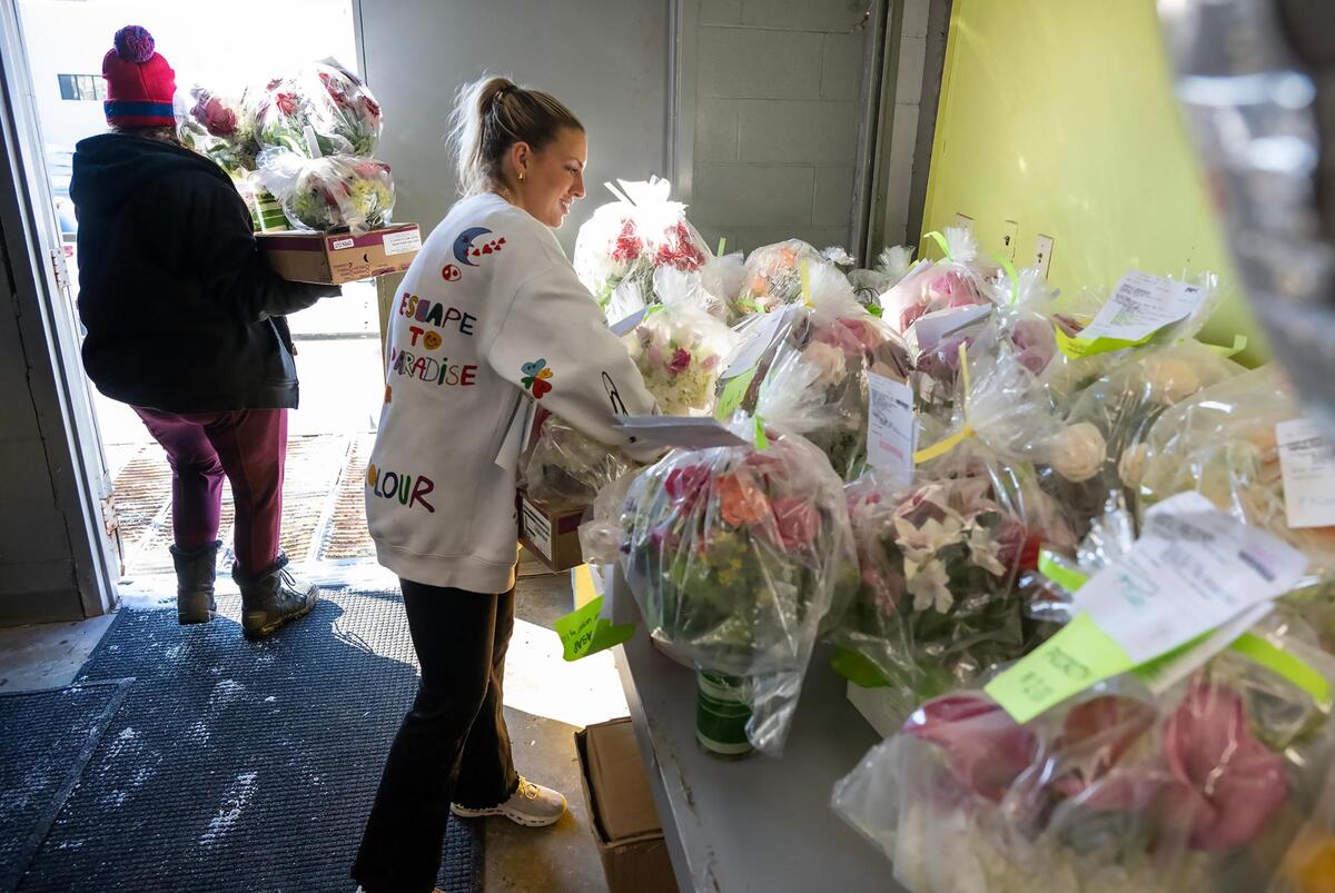 Ashlie Santini, left, a contract delivery driver for Toblers Flowers, and Grace Kost, contract help, prepare Valentine’s Day floral arrangements for delivery on Thursday. The arrangements of fresh flowers need to be protected from the cold and are wrapped in plastic.
