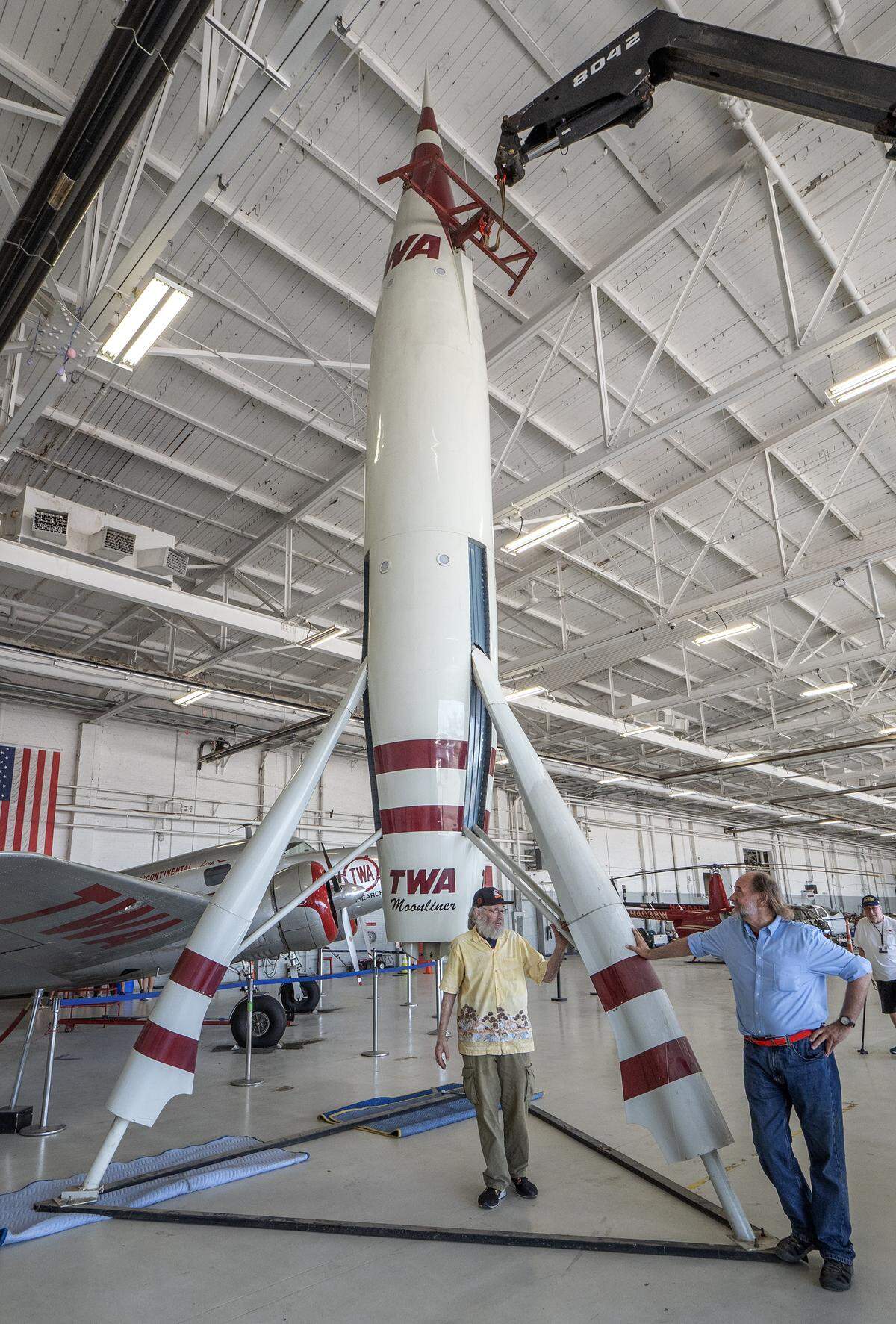 Don Jourdan, left, rebuilt the TWA Moonliner II for its owner, Dan Viets, eright. They posed with the Rocket after its final placment in the TWA Museum. Nearly six hours were required for the intricate, move from the Airline History Museum to its new location.