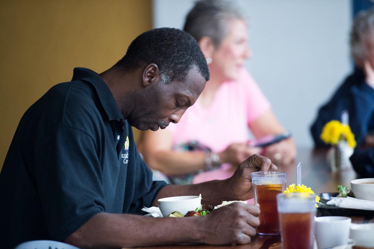 A customer gives a prayer before lunch at Thelma’s Kitchen, Kansas City’s first Pay-What-You-Can community cafe.