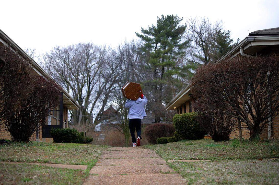 Ronnie Amiyn, housing coordinator for the Criminal Justice Ministry’s Release to Rent program, moves living room furniture on Thursday, March 11, 2021, into a south St. Louis apartment his non-profit acquired for an incoming client. The Release to Rent program finds and prepares places to live for former inmates exiting the corrections system. Photo by Christian Gooden, cgooden@post-dispatch.com