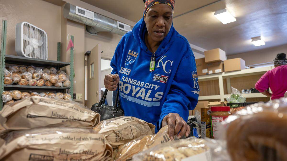 Cynthia Ransburg, a client at the Redemptorist Center, inspects the bread selection on Monday, Nov. 3, 2025, in Kansas City. Food pantries across the region are struggling to meet demand as many families face reduced or frozen SNAP benefits.