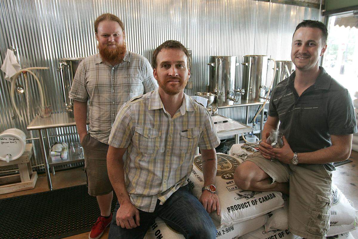 Tyler Jones, a brewing specialist, and two of Brew Lab’s owners, Clay Johnston, center, and Kevin Combs pose for a photo in 2013 at the business, 8004 Foster in downtown Overland Park