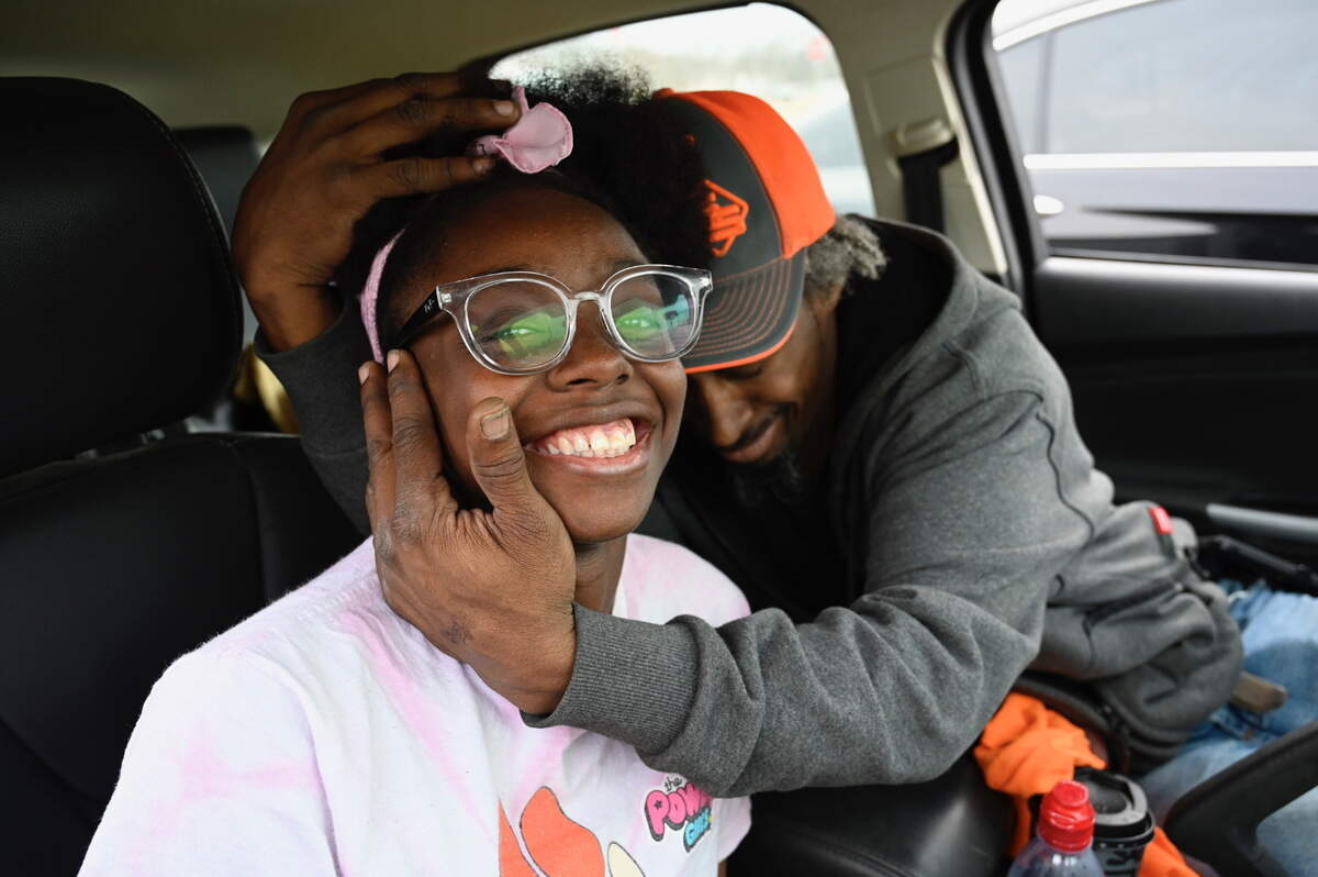 Olathe East High School student Ciara Bridgeforth gets a hug from her dad Brian Bridgeforth after they were reunited at Pioneer Trail Middle School Friday in Olathe.ÊCiara was in the high school when two people were shot there Friday morning.