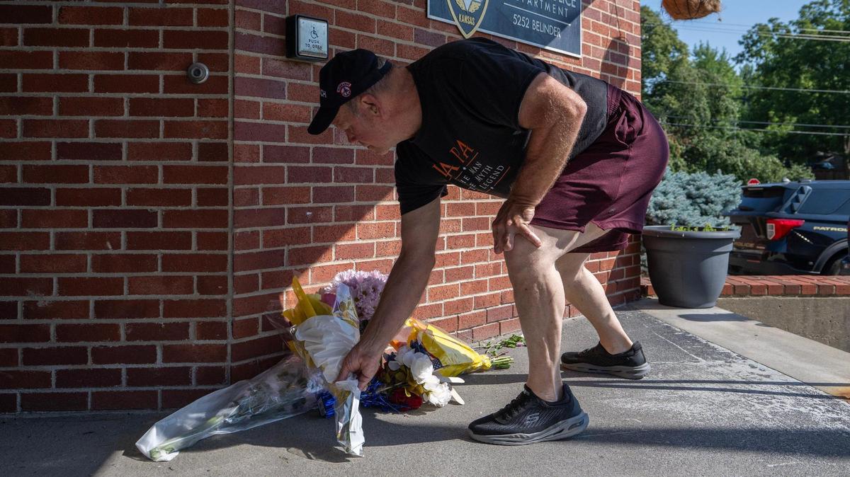 William Thornton, Roeland Park, leaves flowers Tuesday at the Fairway Police Department to pay his respects to Fairway officer Jonah Oswald. Oswald died Monday after being shot in a gun battle with a suspect Sunday at a convenience store in Mission.