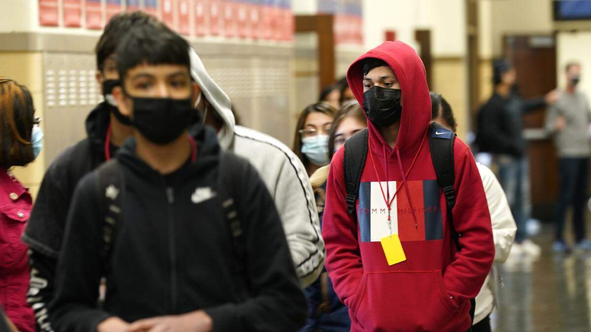 In this March 31 photo, students at Wyandotte High School wear masks in a hallway. De Soto high school students will no longer be required to wear them.
