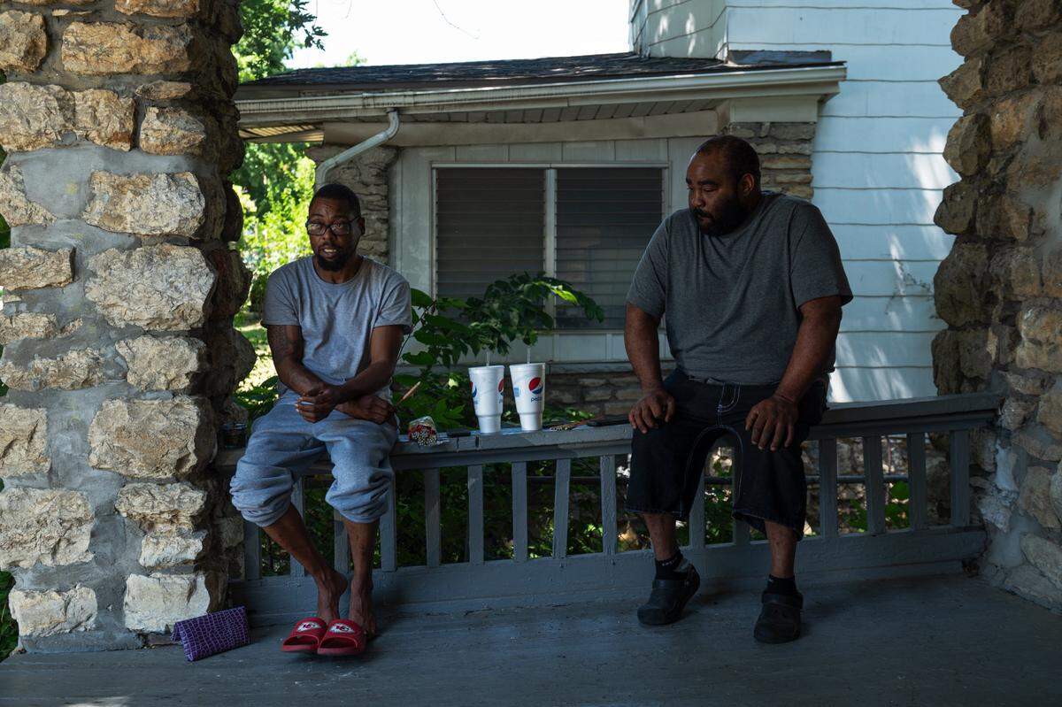 Marlon Kimble, left, and Akeem Paschal sit on the front porch of Kimble’s home in the Oak Park Northwest neighborhood on Tuesday, July 4, 2023, in Kansas City. “When I see big clusters of families, barbecues, and fireworks I think about just 430 something years ago we wasn’t able to enjoy fireworks or enjoy our families,” Paschal said. “Times have changed though, It’s still a day of celebration, it’s a beautiful holiday.”