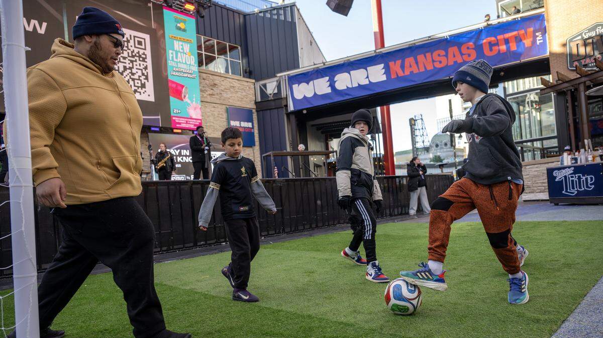 Children play on a mini pitch in front of the stage during the FIFA World Cup draw watch party at the Power & Light District on Friday, Dec. 5, 2025, in Kansas City,