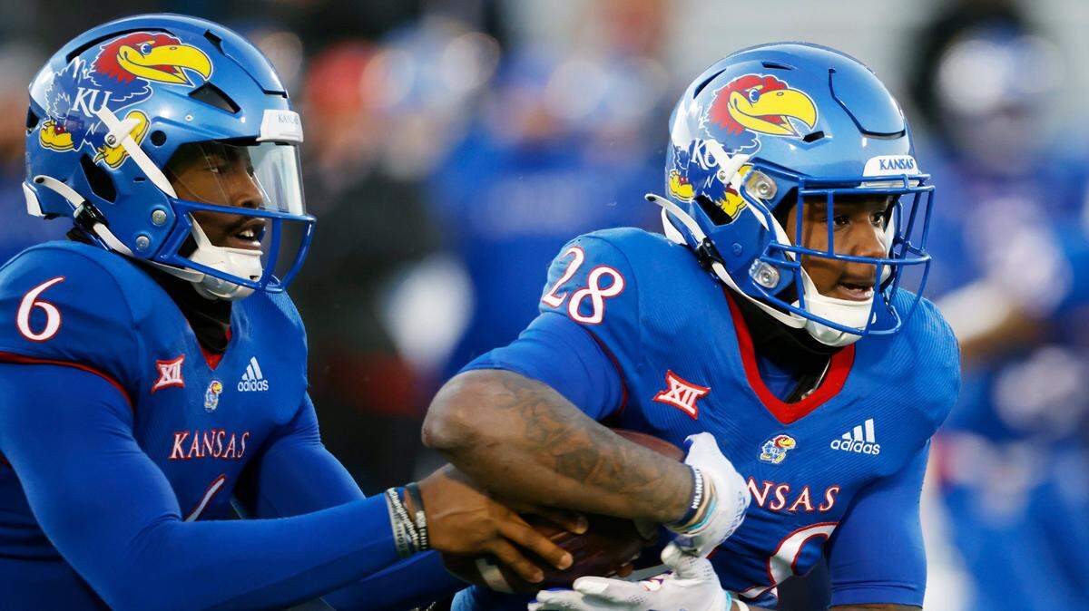 Kansas quarterback Jalon Daniels (left) hands the ball off to Kansas running back Sevion Morrison during the third quarter against Texas on Saturday, Nov. 19, 2022, in Lawrence.