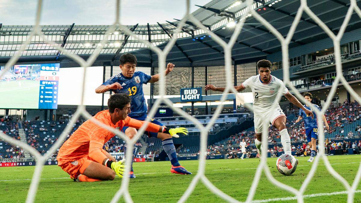 Japan forward Mao Hosoya (19) scores a goal against United States defender Nathan Harriel (2) and goalkeeper Patrick Schulte (1) during the second half at Children’s Mercy Park on June 11, 2024.