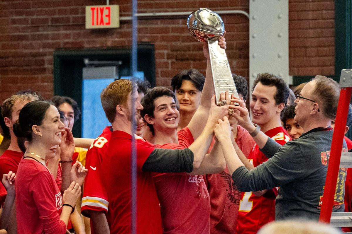 A mirror in the rehearsal studio reflects Kansas City Ballet Company dancers hoisting a replica of the Lombardi Trophy along with championship rings during a rehearsal for the recording of the dance-off.
