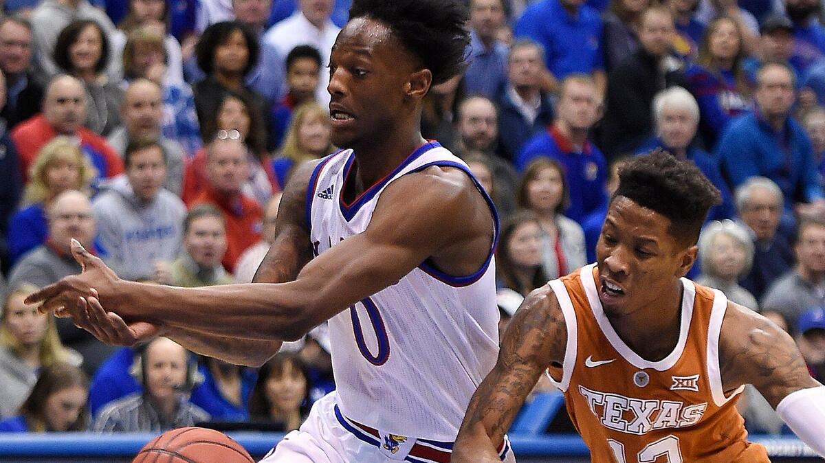 KUâ€™s Marcus Garrett, left, tries to gain control of the ball as Texasâ€™ Kerwin Roach tries to knock the ball away from him during the first half of Monday nightâ€™s game at Allen Fieldhouse.