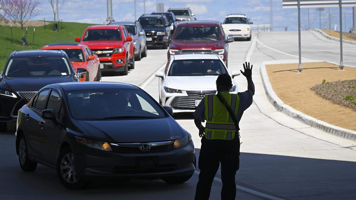 Clyde Kemp Jr., a traffic control officer, signals for drivers to slow up as they arrive Friday, April 21, 2023, to pick up passengers at the new terminal at Kansas City International Airport. The airport is expecting an increase in passenger traffic with the upcoming NFL Draft.