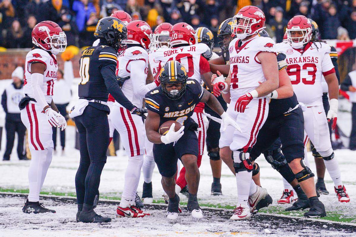 Missouri Tigers running back Marcus Carroll (front and center) scores a touchdown against the Arkansas Razorbacks during the regular-season college football finale for both teams at Faurot Field at Memorial Stadium in Columbia on Saturday, Nov 30, 2024.
